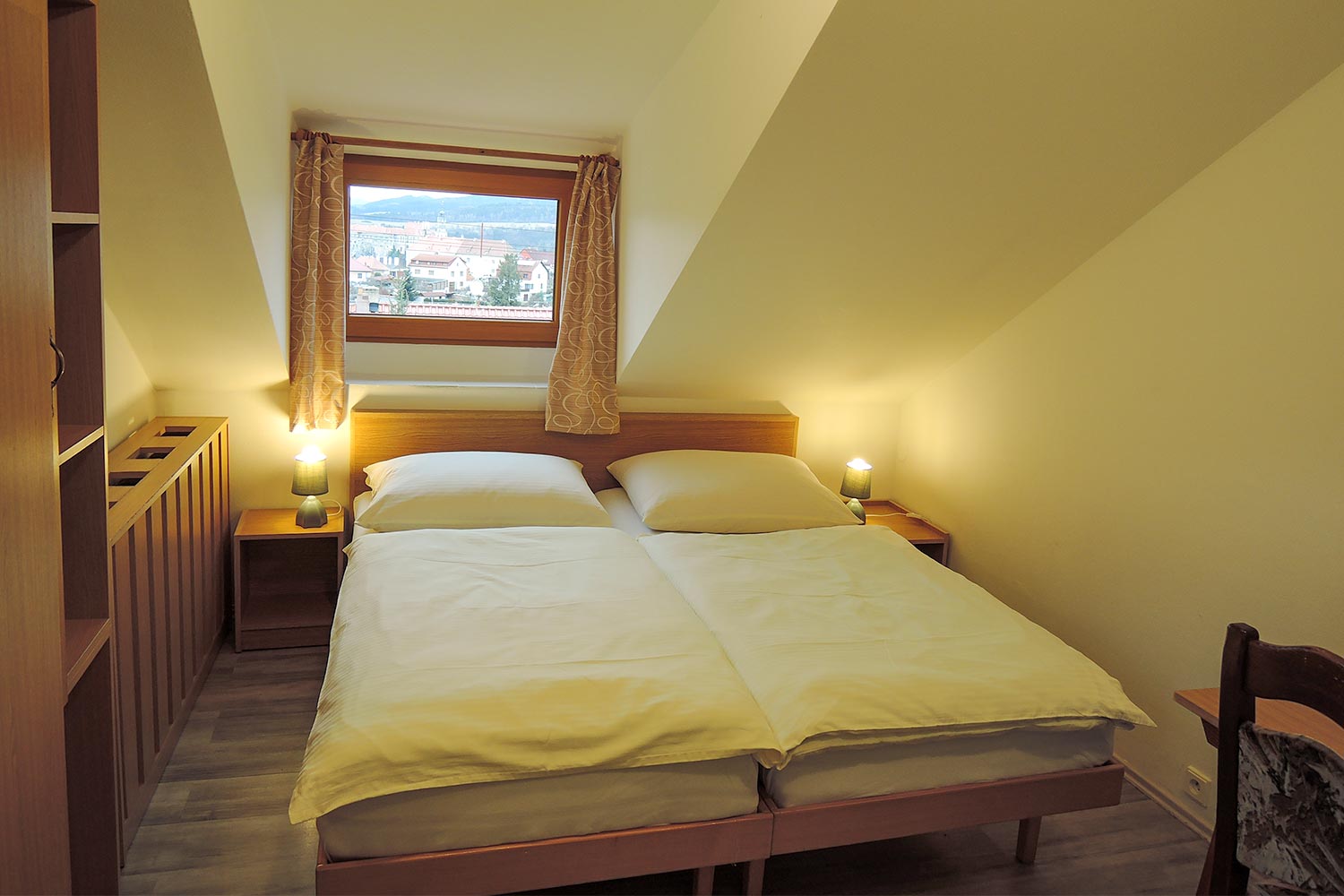 Dvojlůžkový pokoj - pohled na postel a okno